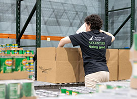 National Life Group employees with cart of meals to donate for community Thanksgiving